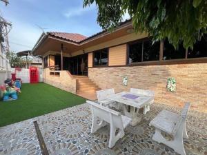 a patio with a table and chairs in front of a house at Pool Smile Villa in Bangsaen