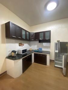 a kitchen with black and white cabinets and appliances at Pool Smile Villa in Bangsaen +23 photos