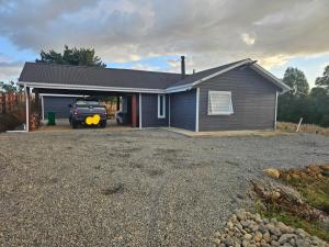 a house with a truck parked in front of it at Casa Parcela, Bosques de Frutillar in Frutillar