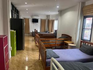 a room with two beds and a living room at Baansuan Runjuan Suratthani บ้านสวนรัญจวนสุราษฎร์ธานี in Ban Huai Chiat