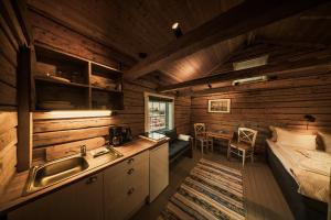 a kitchen with a sink and a bed in a room at Henningsvær Rorbuer in Henningsvær