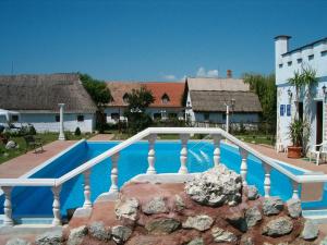 a swimming pool with a white rail next to a building at Kentaur Üdülőfalu in Balatonboglár