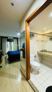 a bathroom with a toilet and a room with a bed at Flat aconchegante in Brasilia