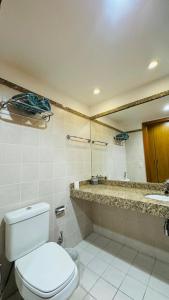 a bathroom with a toilet and a sink and a mirror at Flat aconchegante in Brasilia