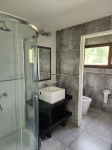 a bathroom with a sink and a glass shower at Casa Victoria - Valle Grande in San Rafael +2 photos