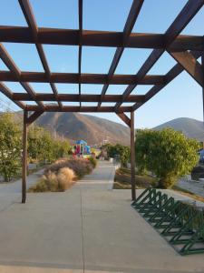 a wooden pavilion with a mountain in the background at Casa TREKKING TOUR ESTANCIA EL SAUCE COQUIMBO in Coquimbo +6 photos