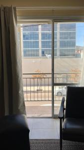 a room with a window with a view of a building at Departamento frente al Arena Maipú Mendoza in Maipú +7 photos