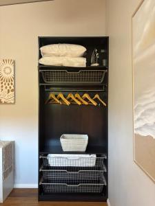 a black walk in closet with lots of shoes at Panda's Patch Dunsborough in Dunsborough