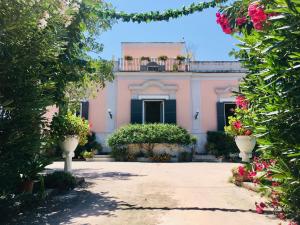 a pink house with flowers in front of it at Il Podere in Trani