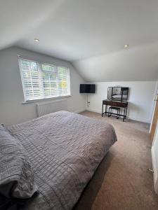 a bedroom with a bed and a window and a chair at Brentwood Essex Work and Family Accommodation with 4 Ensuites and Secure Parking in Brentwood