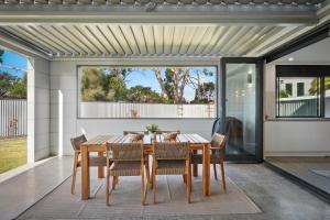 a dining room with a table and chairs at Beautiful Balook - 3 Bedroom Beach House in Lauderdale