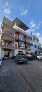 a large building with cars parked in a parking lot at The White Yak Hotel in Leh