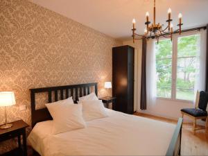 una camera da letto con un letto bianco, una finestra e un lampadario pendente di Château médiéval avec piscine privée et jardin, animaux acceptés - FR-1-381-410 a Saint-Bauld Altre 22 foto