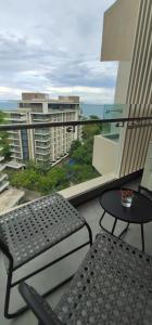 un balcon avec un banc et une table et une vue dans l'établissement STUDIO DELUXE OCEAN VIEW in TAMBULI SEASIDE RESORT & SPA only 1 residential pool is free to use, à Lapu Lapu City