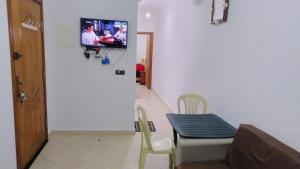 a living room with a couch and a tv on a wall at Apartment 20m from Martil beach in Tétouan