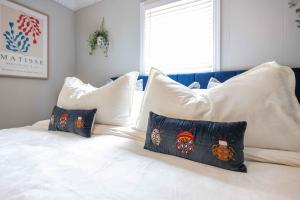 a white bed with pillows on top of it at Lake Oliver Cottage Near Fort Benning & Downtown Columbus in Columbus