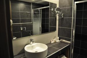 a bathroom with a sink and a mirror at Minoa Hotel in Tolo