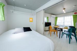 a bedroom with a bed and a table with chairs at RECO Waseda in Tokyo