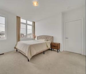 a white bedroom with a bed and a window at Cambridge Luxury by Ravine in Cambridge