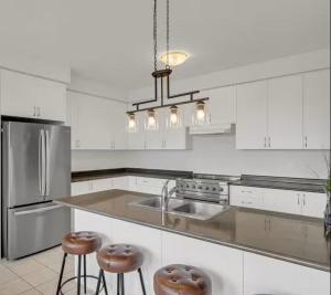 a kitchen with white cabinets and stainless steel appliances at Cambridge Luxury by Ravine in Cambridge
