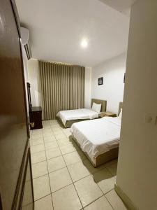 a hotel room with two beds and a mirror at فيلا بيتا خصوصيه في الشاطئ والمسبح in Durat Alarous +26 photos