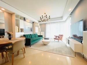 ein Wohnzimmer mit einer grünen Couch und einem Tisch in der Unterkunft iHome-Lujiazui Riverside, Shanghai's Leading Advocate for Genuine Apart ment - Committed to Quality, Bund RiverView&CityWalk, Deluxe Neighborhood in Shanghai