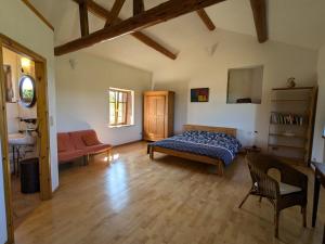a bedroom with a bed and a couch in a room at Gîte paisible avec jardin et possibilité d'animaux à Gruey-lès-Surance - FR-1-589-814 in Gruey-lès-Surance