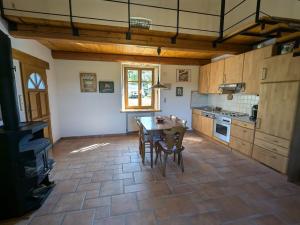 a kitchen with a table and chairs in a room at Gîte paisible avec jardin et possibilité d'animaux à Gruey-lès-Surance - FR-1-589-814 in Gruey-lès-Surance
