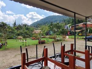 a view of a park from a porch with chairs at อินทนนท์ บ้านพักเล่าจู Inthanon Laoju House in Ban Na Yang