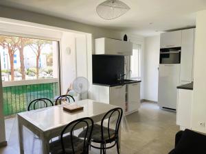 a kitchen and dining room with a table and chairs at La Grande Motte: Appart 2 pièces lumineux, 4 couchages, parking privé - FR-1-790-35 in La Grande-Motte