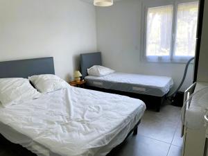 a bedroom with two beds and a window at La Grande Motte: Appart 2 pièces lumineux, 4 couchages, parking privé - FR-1-790-35 in La Grande-Motte