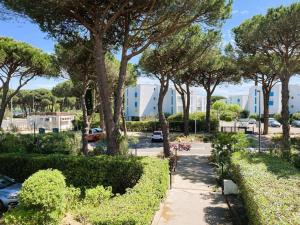 a walkway in a park with trees and a parking lot at La Grande Motte: Appart 2 pièces lumineux, 4 couchages, parking privé - FR-1-790-35 in La Grande-Motte