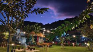 a garden lit up at night with lights at อินทนนท์ บ้านพักเล่าจู Inthanon Laoju House in Ban Na Yang