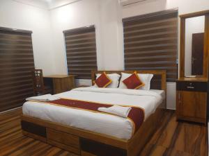 a bedroom with a large bed and a television at VGK Residency in Wayanad +46 photos