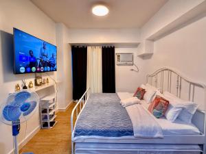 une petite chambre avec un lit et une télévision à écran plat dans l'établissement Daily Rental Units in 8 Adriatico Manila, à Manille