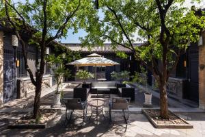 平遥Elsewhere Hotel Inn North Street Branch的有桌椅和树木的露台