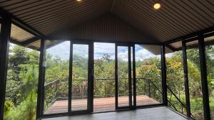 a screened in porch with a view of the forest at Lilys Stone Garden Bungalow in Tram de Dak Mil