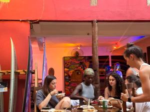 a group of people sitting at a table in a restaurant at Mais Que Nada Itacaré - Hostel, Bar & Breakfast in Itacaré