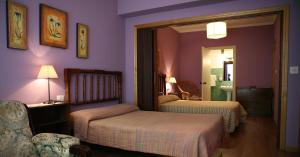 una habitación de hotel con 2 camas y una silla en Casa Matías, en Sarria