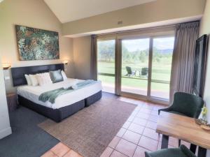 una camera da letto con un letto e una grande finestra di Rothbury Downs a Lovedale