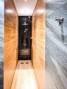 a walk in shower with a wood paneled wall at 4BR Townhouse w Garage, Peaceful near Restaurants in Manila