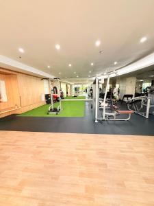 a gym with treadmills and a green carpet at Shell Residences Condotel by PauL in Manila