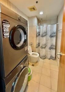 une machine à laver dans une salle de bain avec toilettes dans l'établissement Daily Rental Units in 8 Adriatico Manila, à Manille