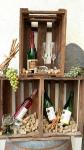 a wooden shelf with wine bottles and wine glasses at Ferienweingut Arnold Thiesen in Bruttig-Fankel