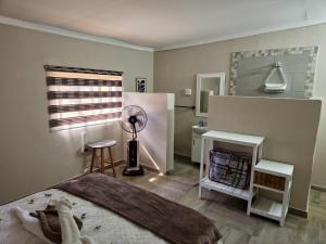a bedroom with a bed with a fan and a mirror at Magalies River Country Retreat in Skeerpoort +40 photos