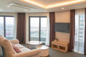 a living room with a couch and a flat screen tv at Chuncheon Eston Hotel in Chuncheon