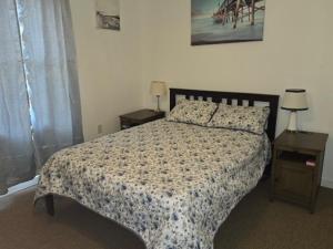 a bedroom with a bed and two tables with lamps at The Happy Place in Glouster