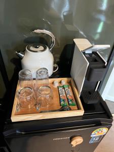 cafetera y vasos encima de una nevera en Nara Black Mountain, en Ban Tha Chang