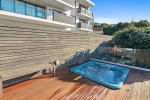 a swimming pool sitting on a deck in front of a house at Kaiteriteri Luxury Apartment in Kaiteriteri