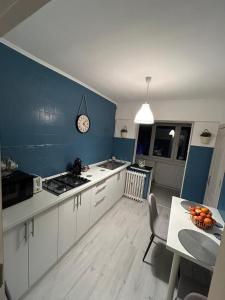 a kitchen with a table and a clock on the wall at Apartament 2 dormitoare ultracentral modern in Craiova